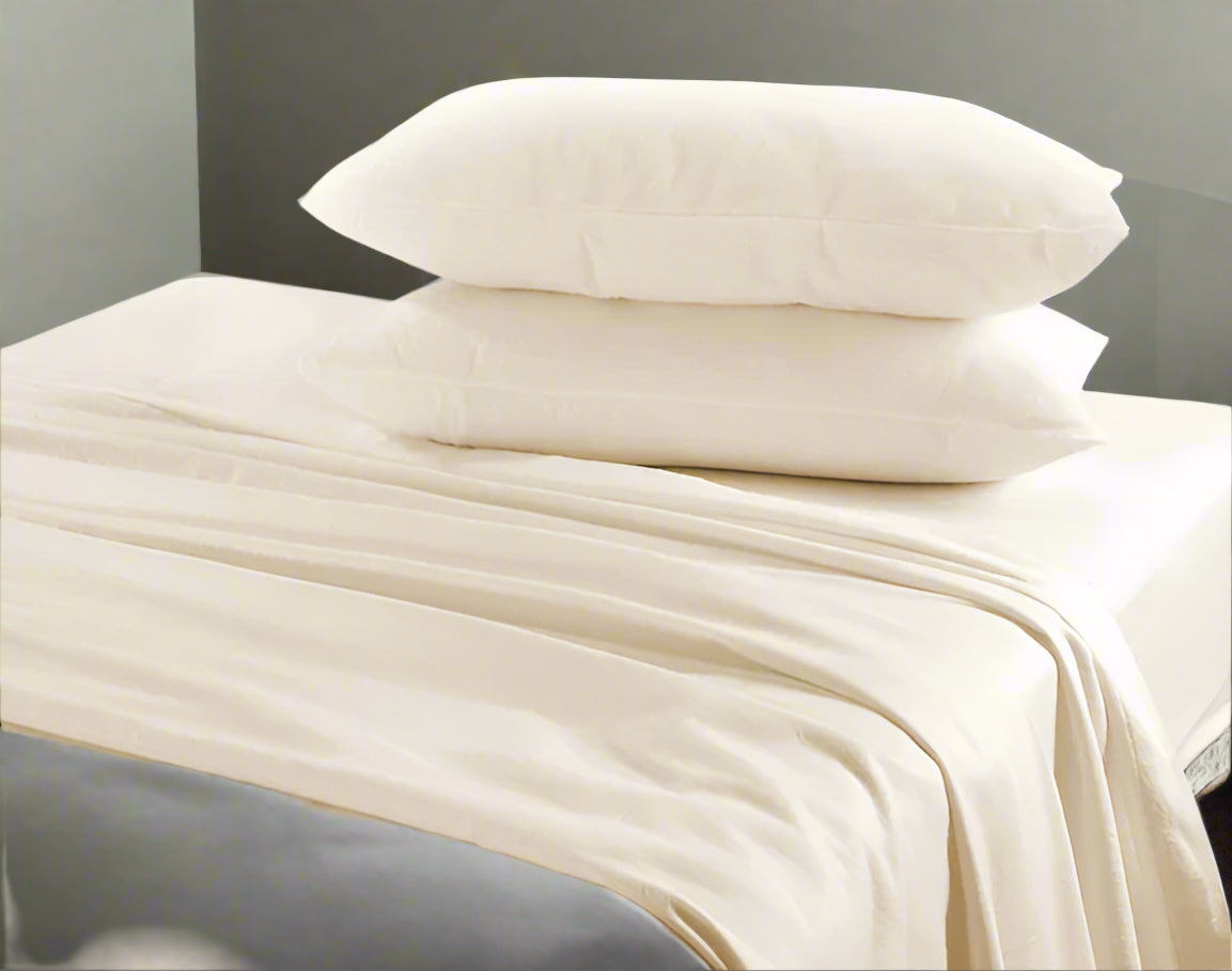 Beige bedding set with pillows on a bed in a bedroom setting.
