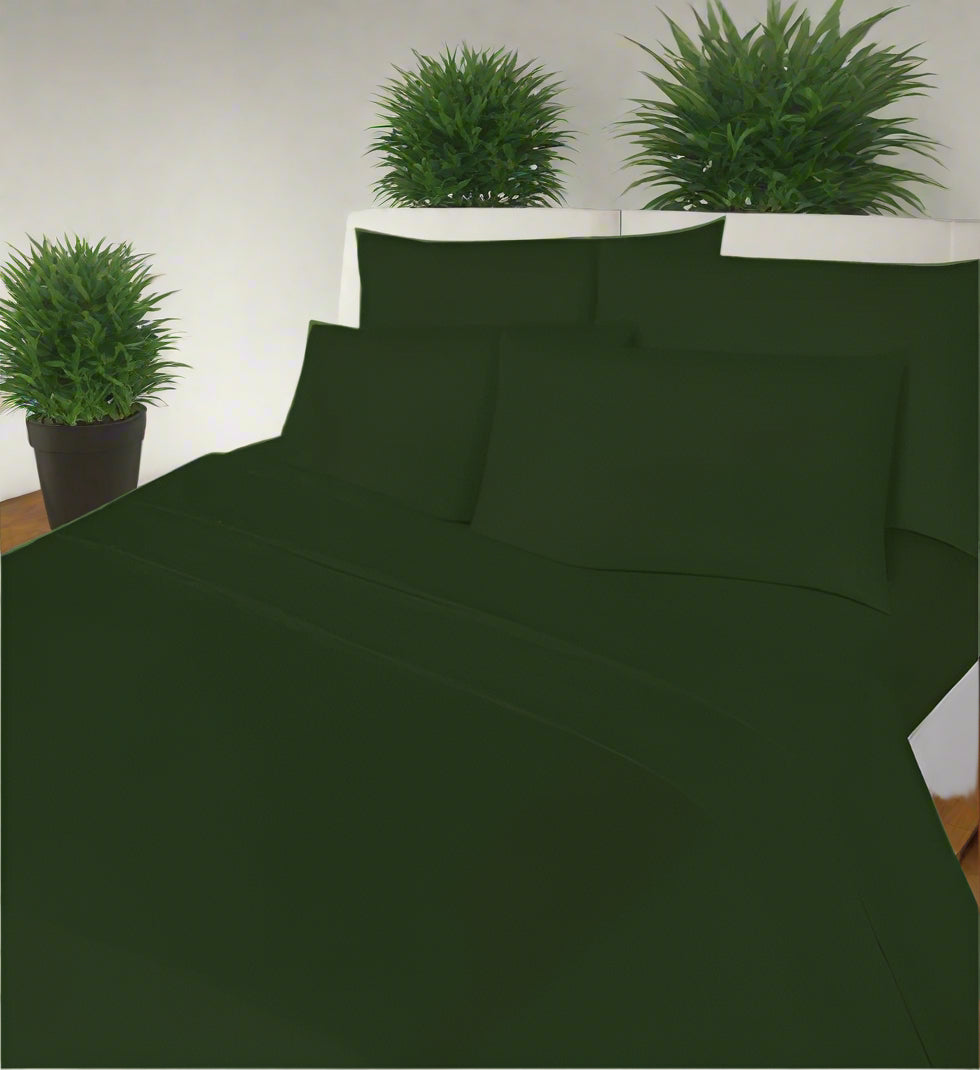 Green bed sheet set on a bed with pillows in a room with a window.