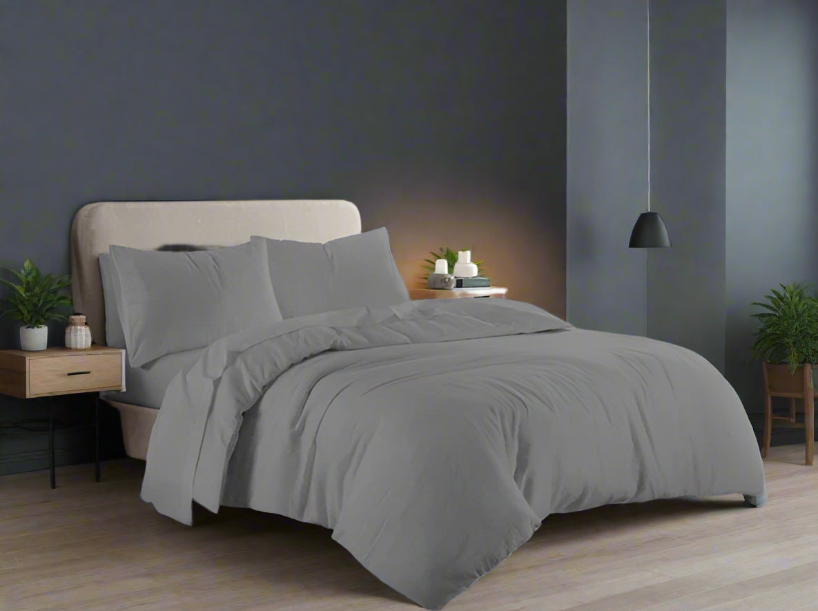 Gray bedding set on a bed in a bedroom with a window in the background