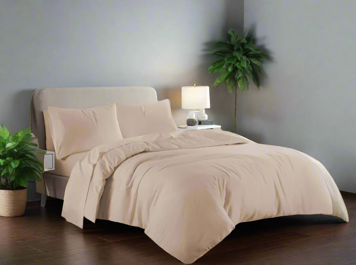 Beige bedding set on a bed in a bedroom with gray walls and wooden floors.