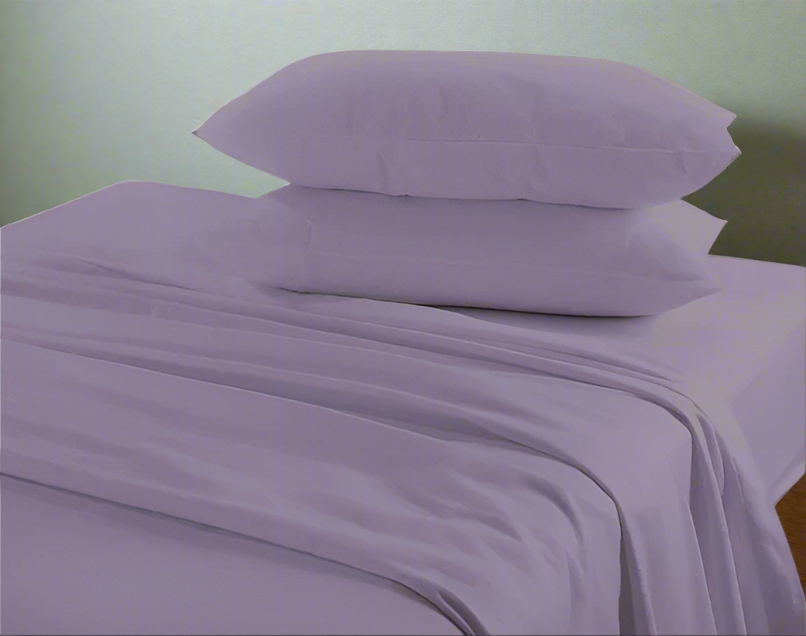 Purple bed sheets and pillows on a bed with a neutral background