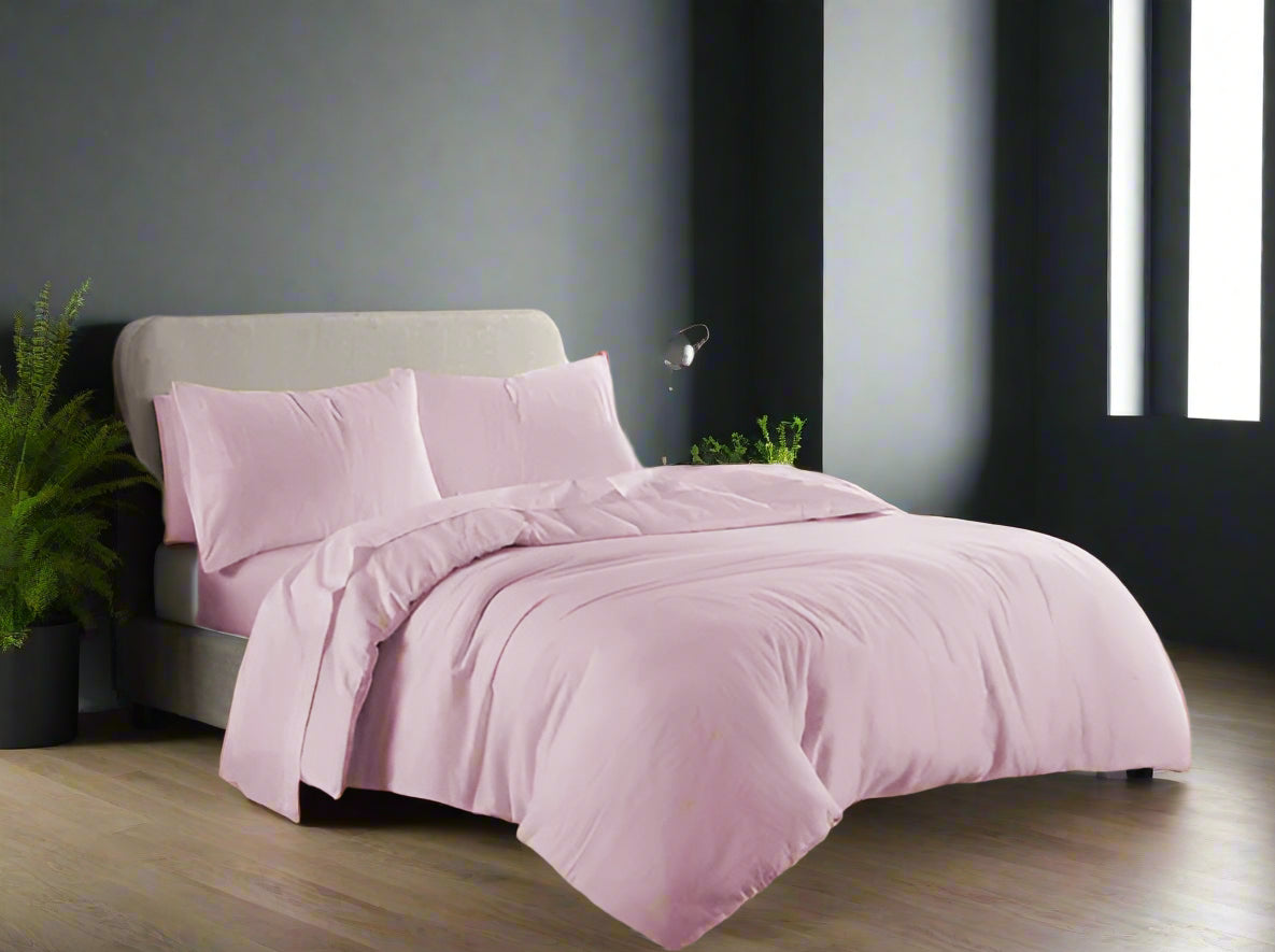 Pink bedding set on a bed in a well-lit bedroom