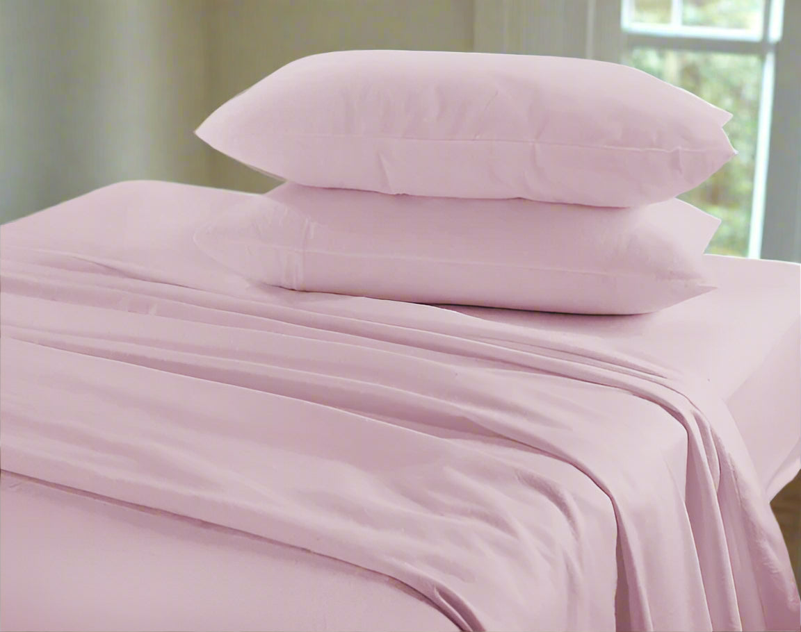 Pink bed sheets and pillows on a bed with a neutral background