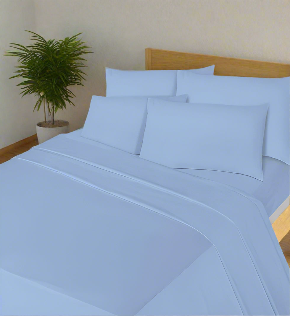Blue bed sheets and pillowcases on a bed in a bedroom setting.