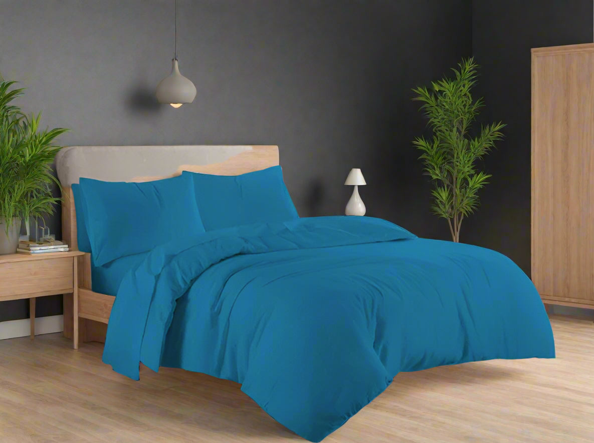 Blue bedding set on a bed in a bedroom with a window in the background