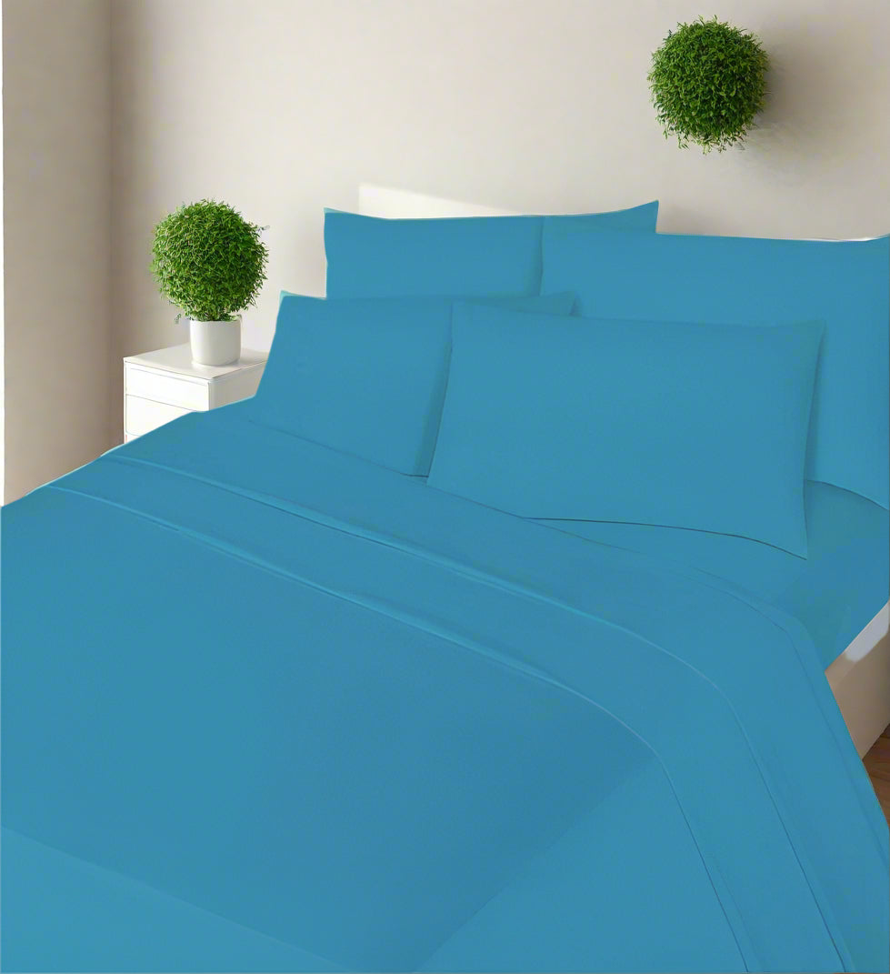 teal bed sheets and pillows on a bed in a bedroom