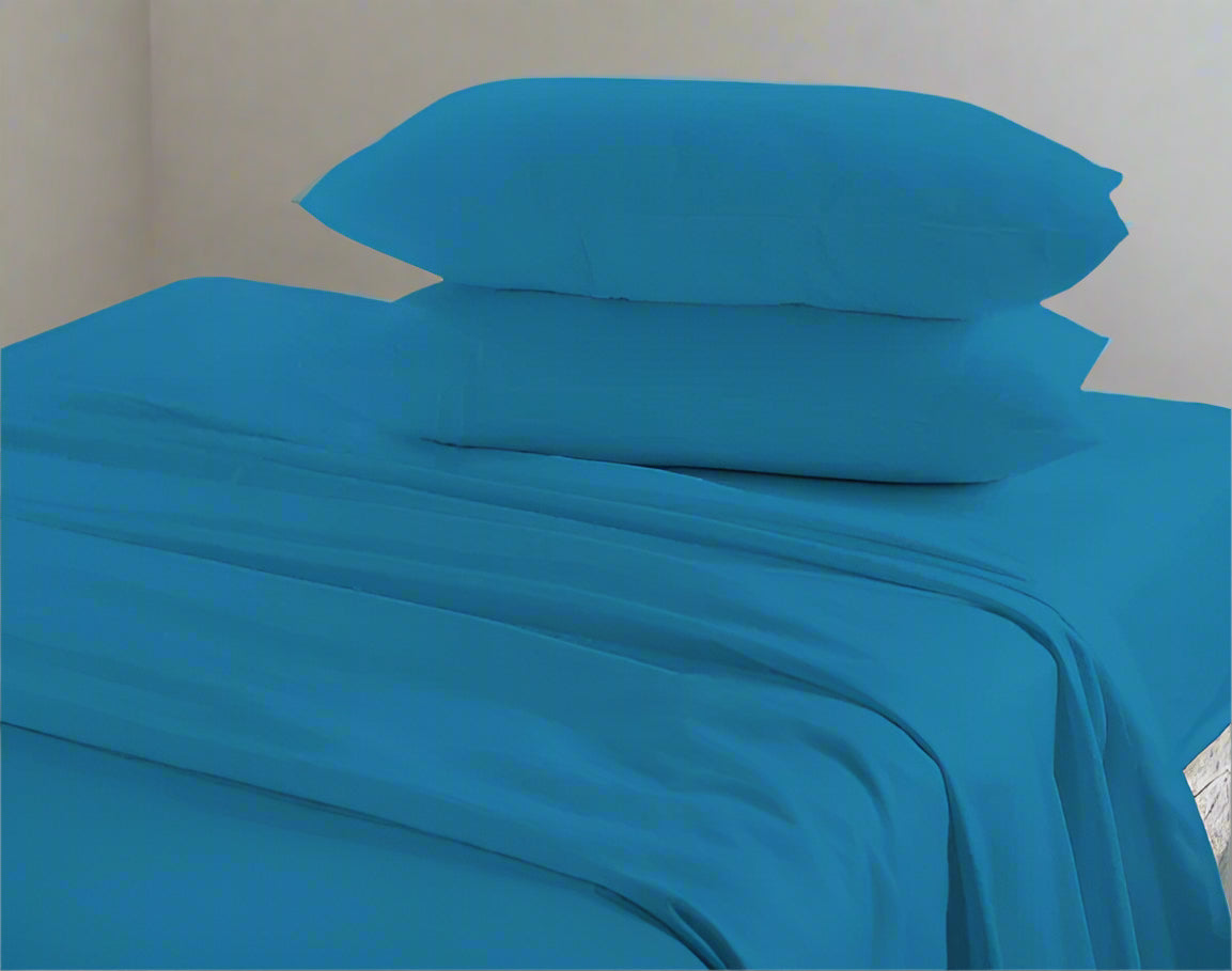 Blue bed sheets and pillows on a bed with a neutral background