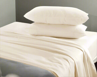 Beige bedding set with pillows on a bed in a bedroom setting.