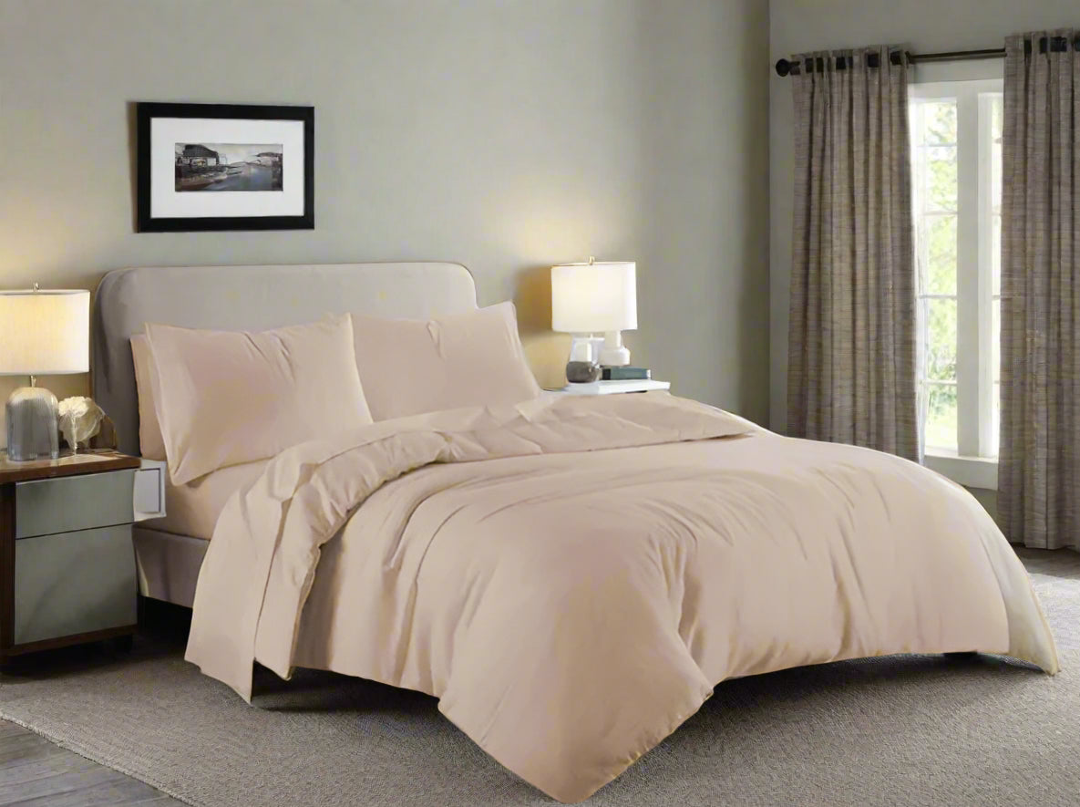 Beige bedding set on a bed in a bedroom with gray walls and wooden floors.