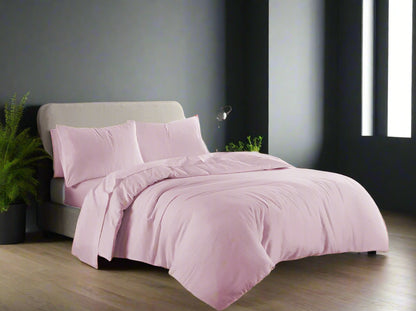 Pink bedding set on a bed in a well-lit bedroom
