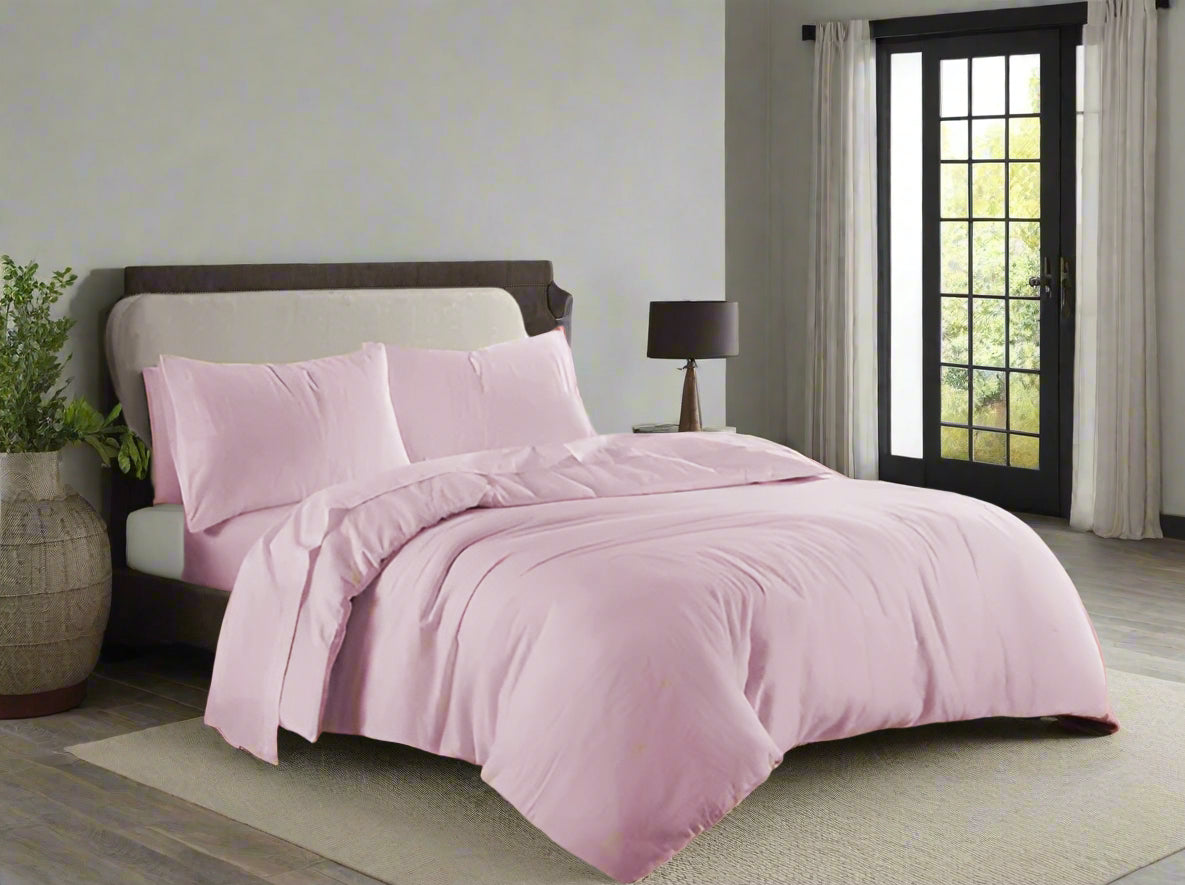 Pink bedding set on a bed in a well-lit bedroom