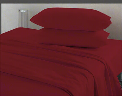 Red bed sheets and pillows on a bed with a neutral background