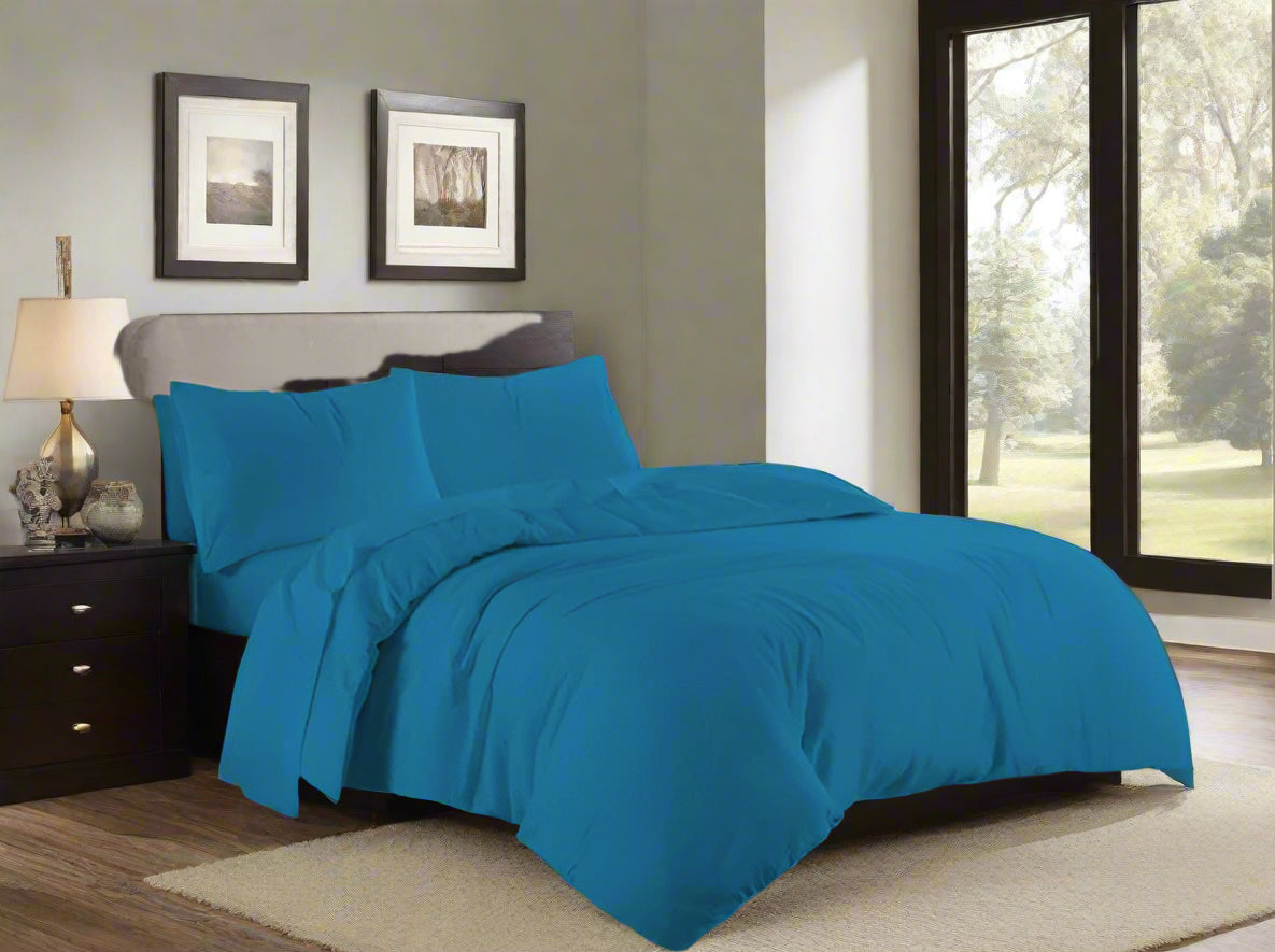 Blue bedding set on a bed in a bedroom with a window in the background