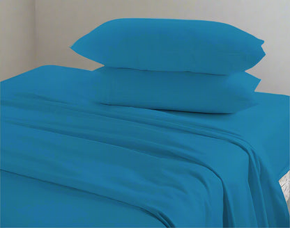 Blue bed sheets and pillows on a bed with a neutral background